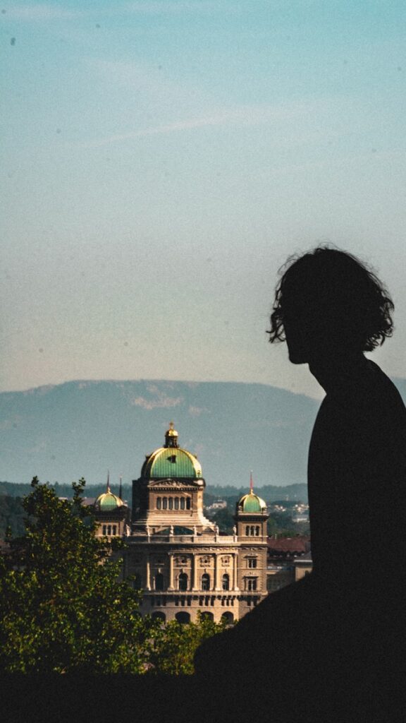 a silhouette of a person standing in front of a building