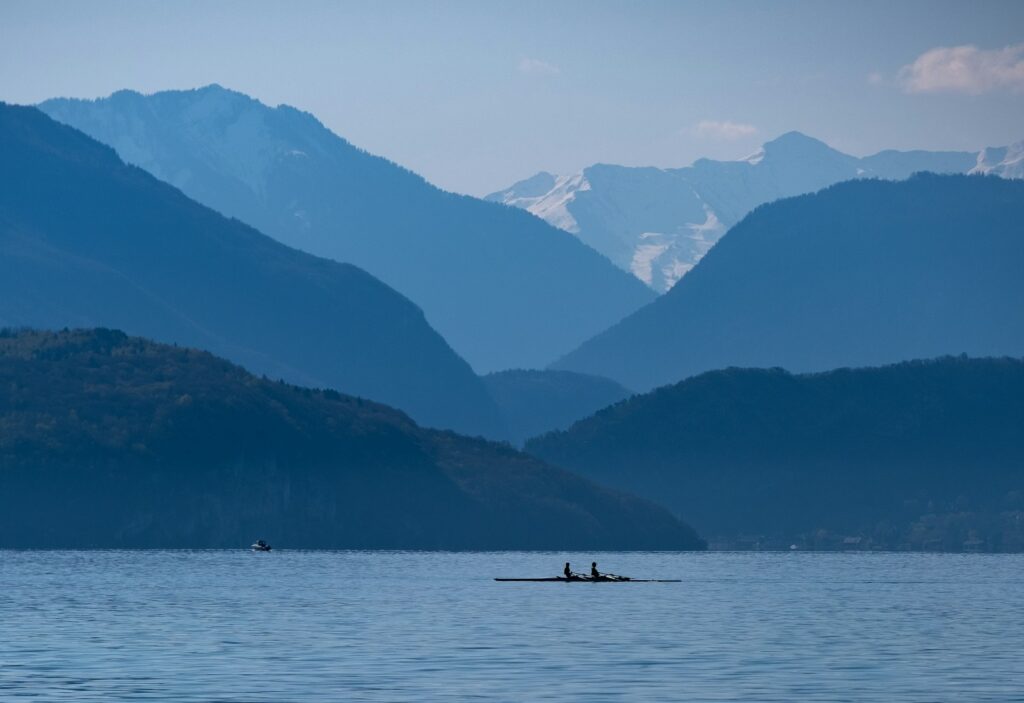silhouette of 2 people riding boat on lake during daytime